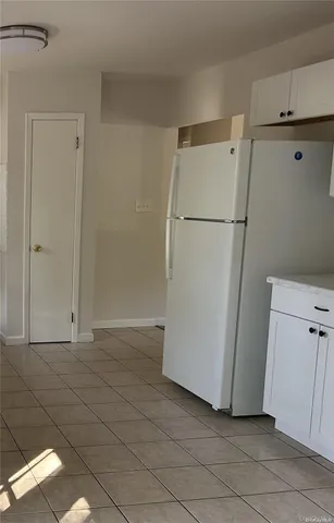 a view of a storage & utility room with refrigerator