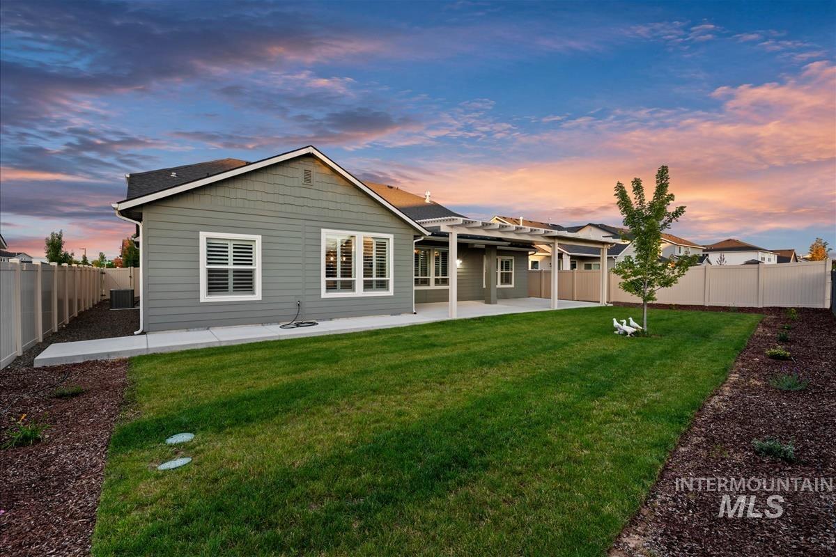 15451 Lutsen Avenue Caldwell, ID 83607 - Photo 38 of 39 Expansive rear yard featuring a manicured lawn, established landscaping beds, and a perimeter fence