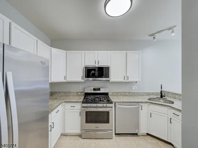 a kitchen with appliances a sink and cabinets