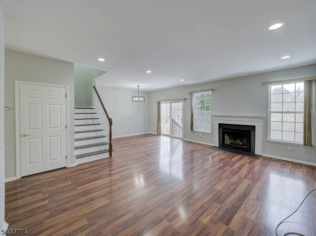 a view of a livingroom with wooden floor fireplace and window