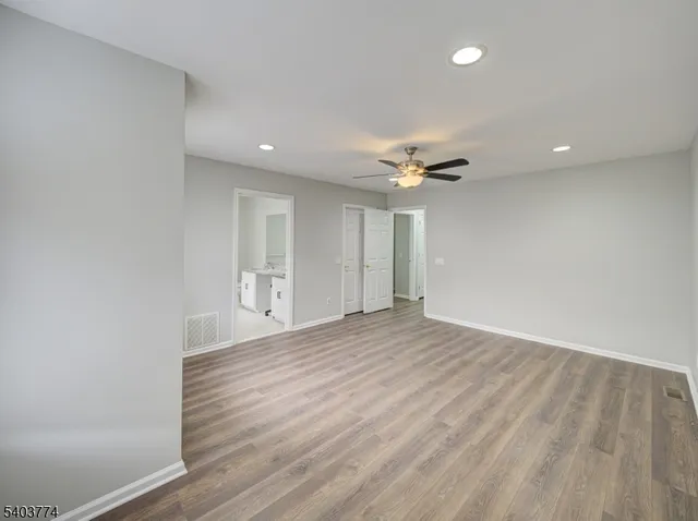 a view of an empty room with wooden floor