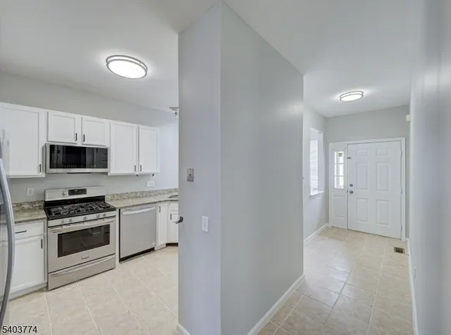 a kitchen with stainless steel appliances white cabinets and sink
