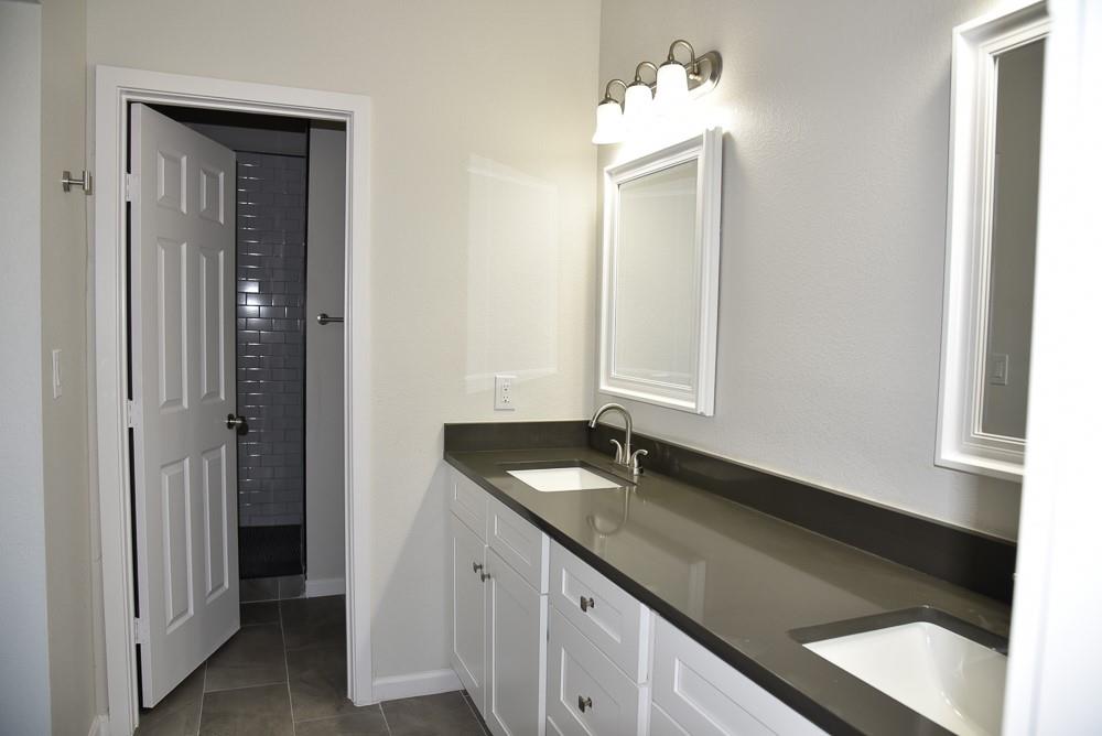 1602 North Mcdonald Avenue Decatur, TX 76234 - Photo 11 of 13 a bathroom with a granite countertop sink and a mirror