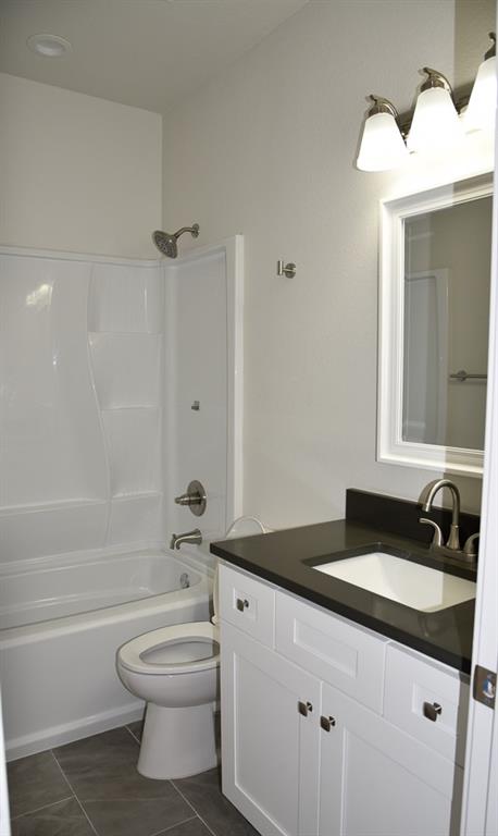 1602 North Mcdonald Avenue Decatur, TX 76234 - Photo 8 of 13 a bathroom with a granite countertop sink toilet a mirror and shower