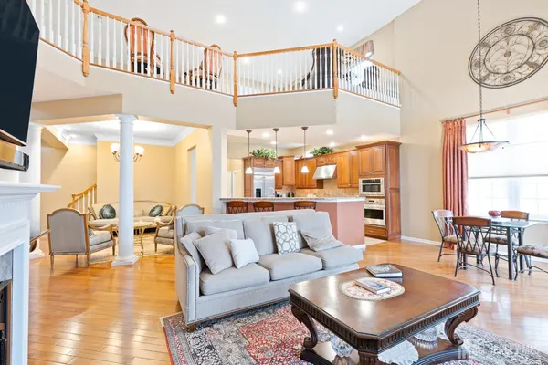 a kitchen with stainless steel appliances granite countertop a stove top oven a sink dishwasher a dining table and chairs with wooden floor