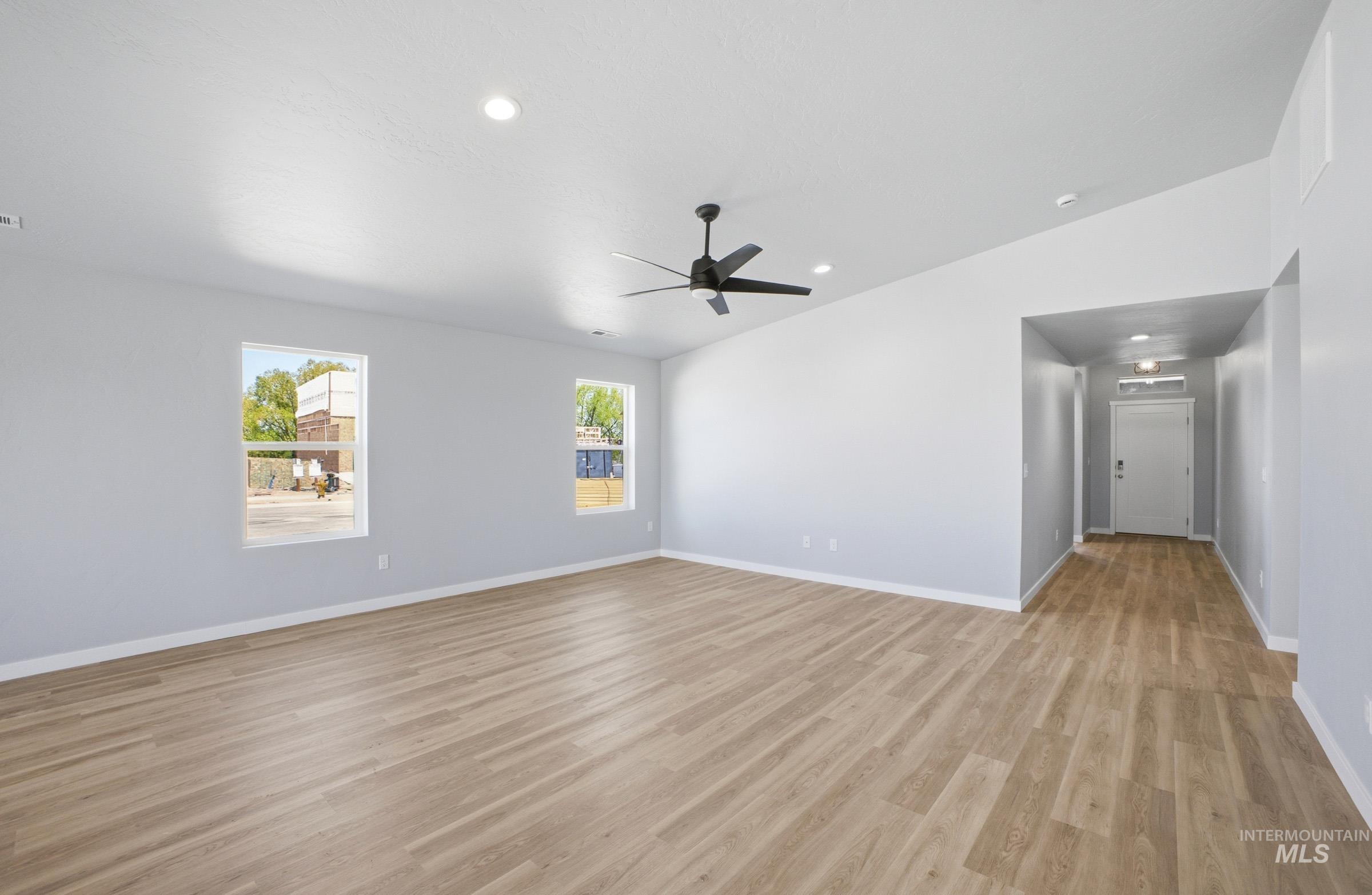 14106 Winding Street Caldwell, ID 83607 - Photo 6 of 18 Spacious room featuring wood-finish flooring, light grey walls, and a contemporary ceiling fan