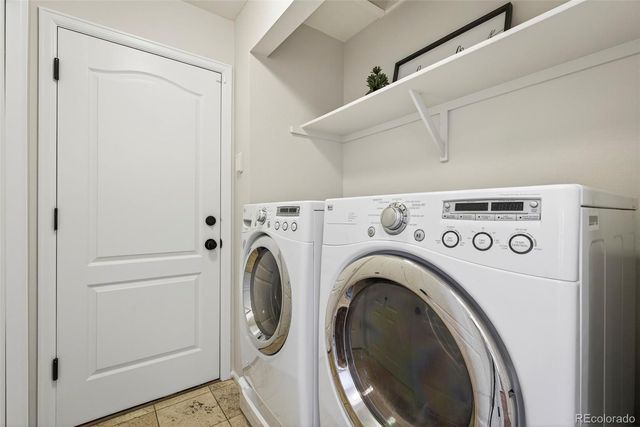 a view of washer and dryer with kitchen in the background