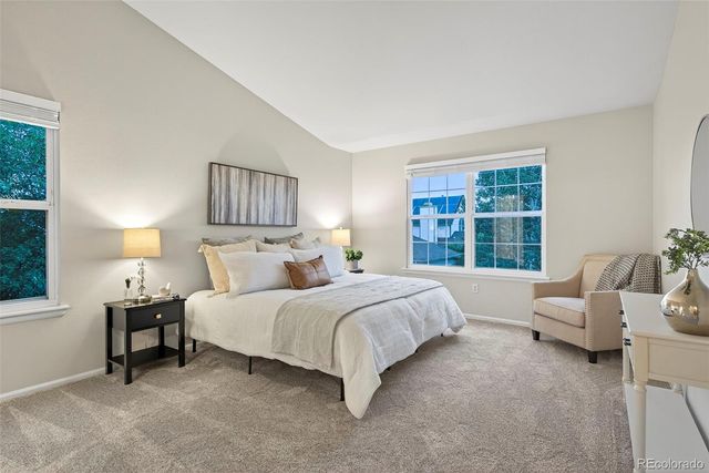 a spacious bedroom with a bed and a couch