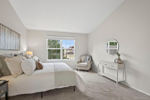 a bed room with a bed a couch and a window