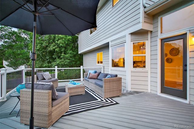 a view of a roof deck with couches under an umbrella