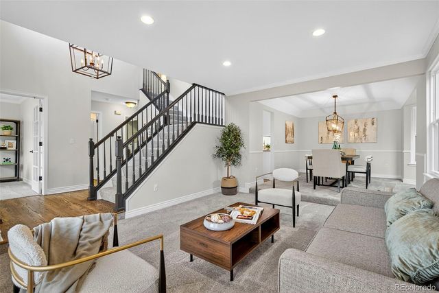 a living room with furniture and a dining table with wooden floor