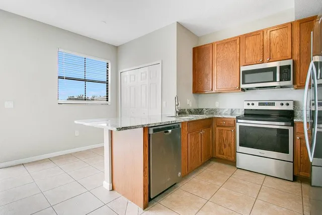 a kitchen with stainless steel appliances granite countertop a refrigerator and a stove top oven