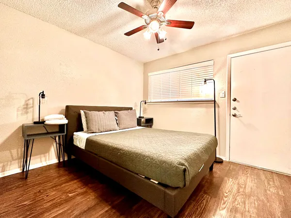a bedroom with bed and wooden floor