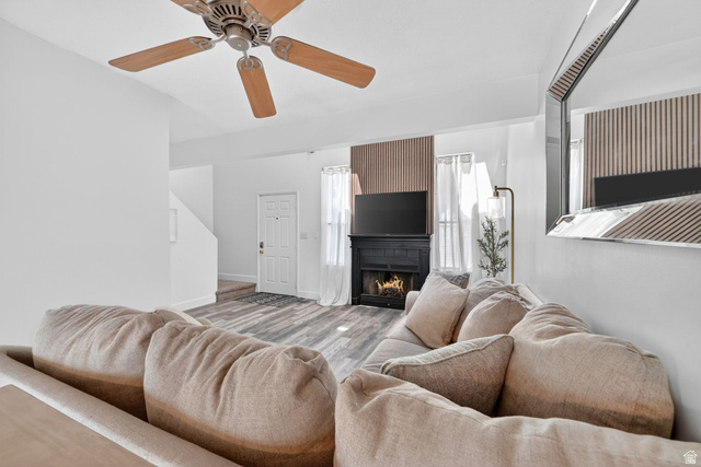 788 East Gables Street Midvale, UT 84047 - Photo 4 of 24 Open-concept living space featuring , a ceiling fan, and a fireplace with a decorative wooden slat wall