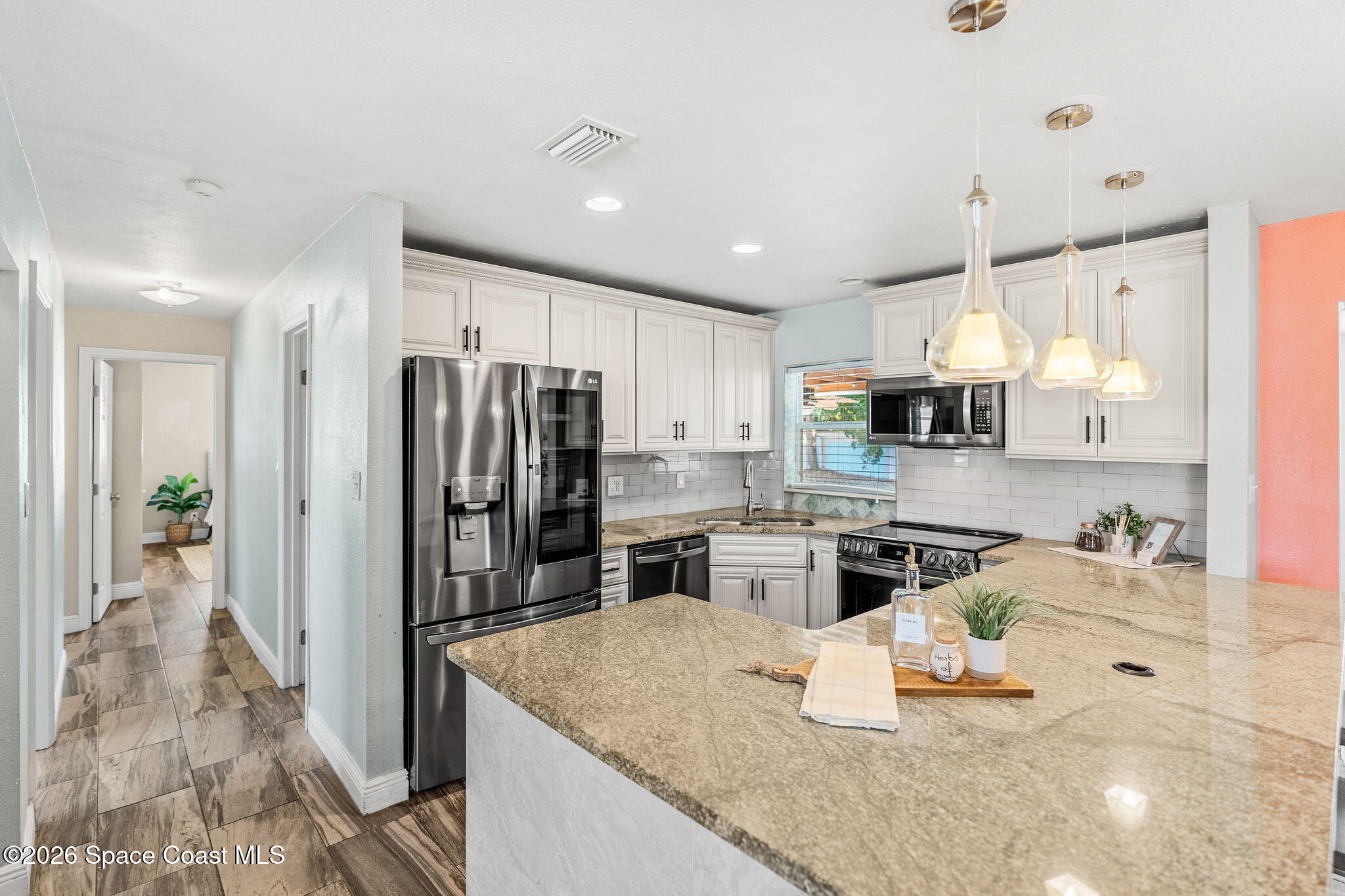 340 West Exeter Street Satellite Beach, FL 32937 - Photo 13 of 39 a kitchen with stainless steel appliances granite countertop a sink refrigerator and cabinets
