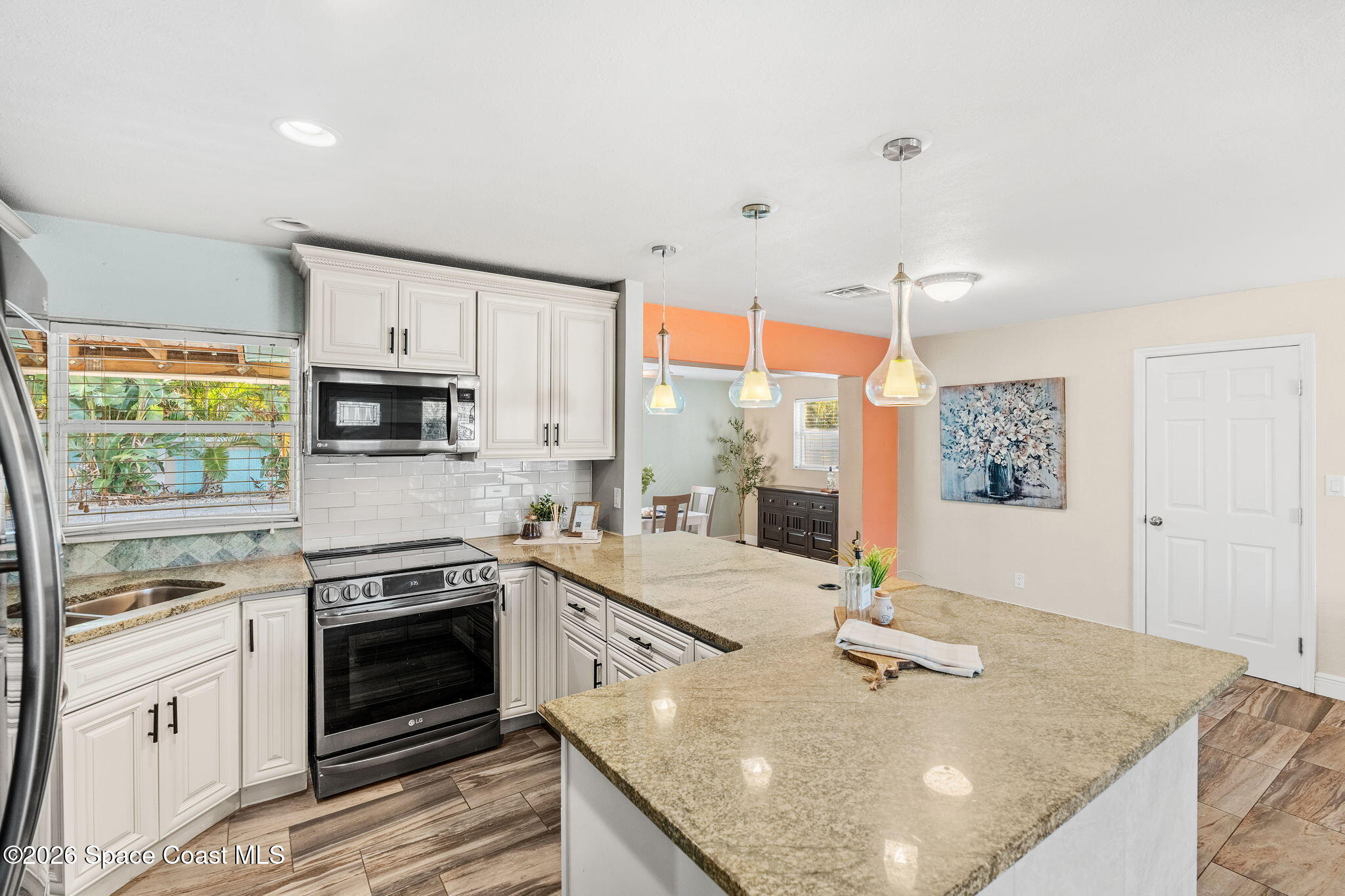 340 West Exeter Street Satellite Beach, FL 32937 - Photo 16 of 39 a open kitchen with stainless steel appliances granite countertop a stove a sink and a microwave