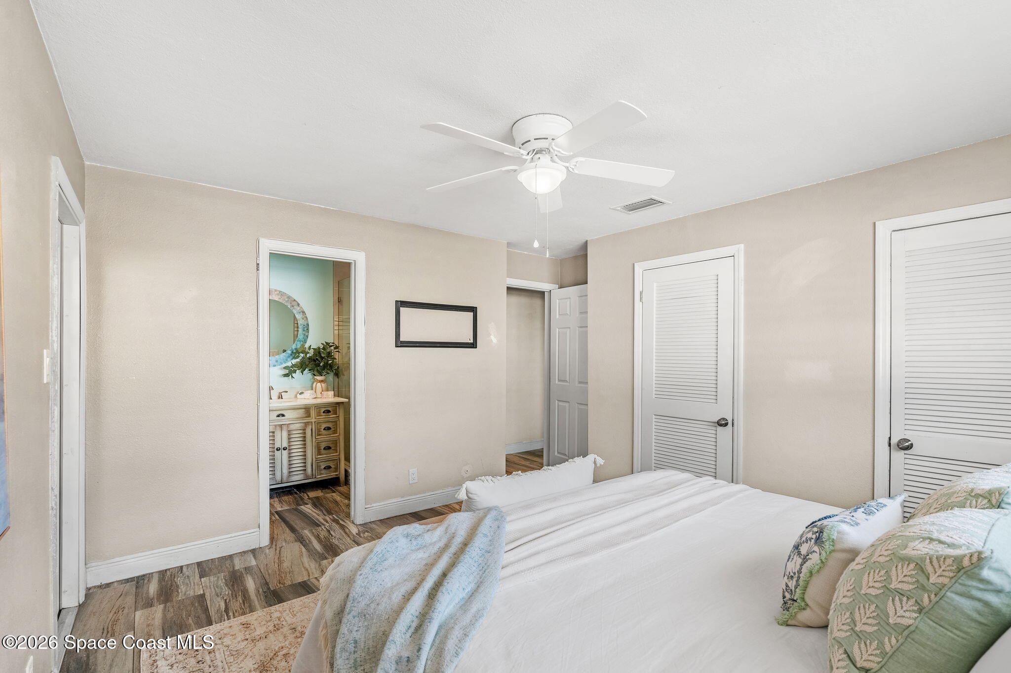 340 West Exeter Street Satellite Beach, FL 32937 - Photo 20 of 39 a bedroom with a bed and a chandelier