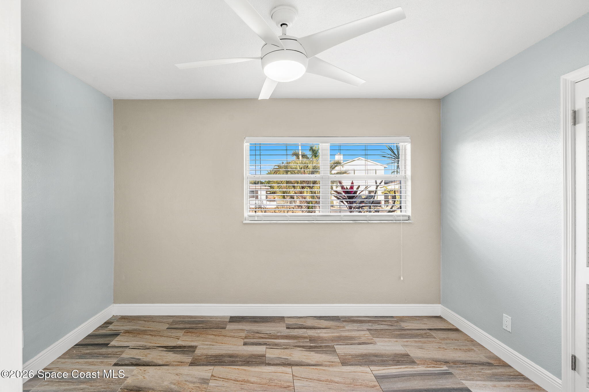 340 West Exeter Street Satellite Beach, FL 32937 - Photo 22 of 39 an empty room with wooden floor and fan