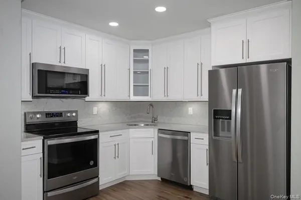 a kitchen with cabinets stainless steel appliances and a counter space