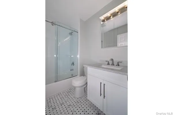 a bathroom with a sink a toilet and a mirror