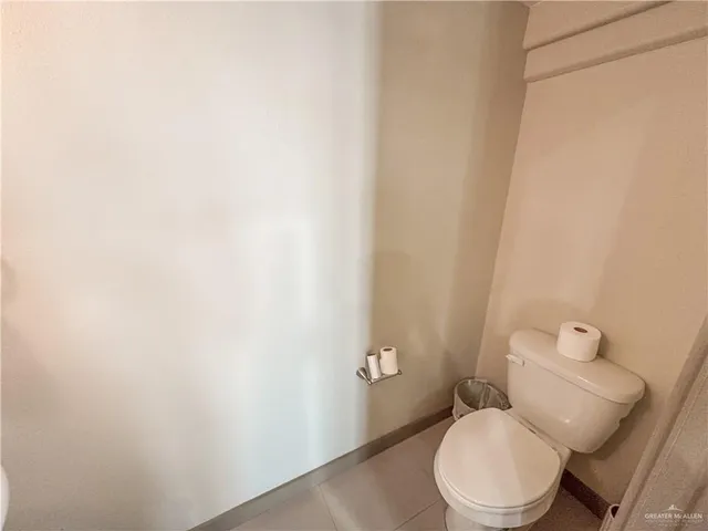 a white toilet sitting next to a white wall
