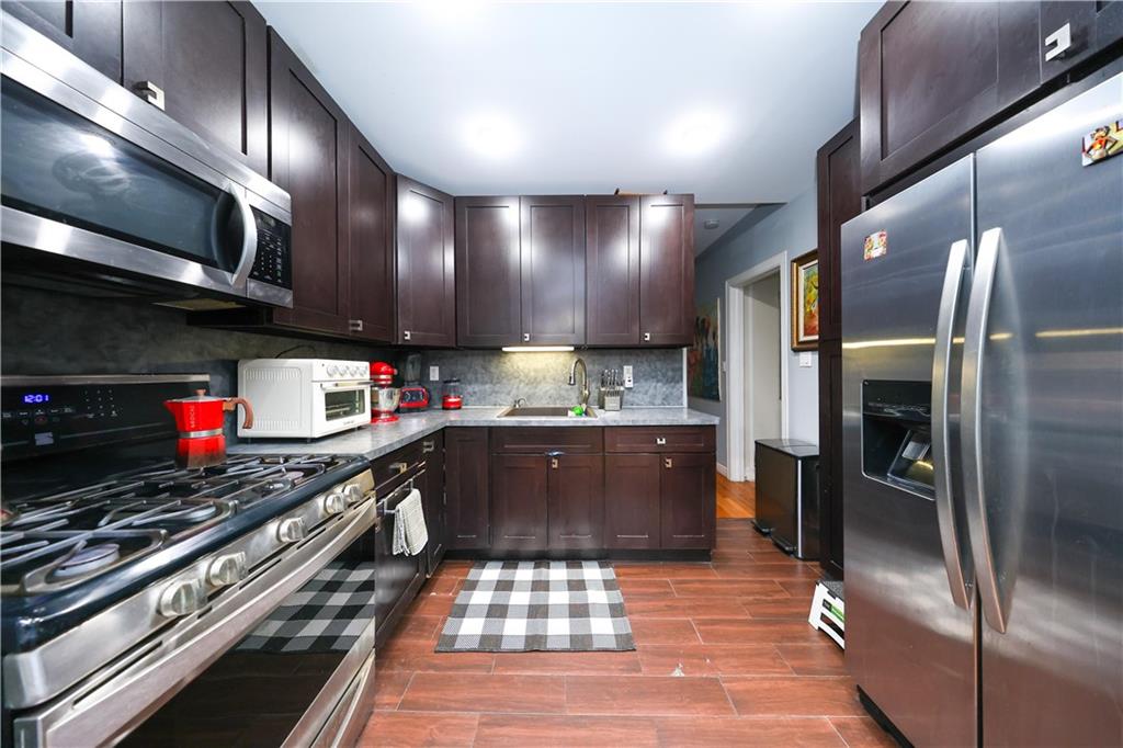 1200 East 49th Street Brooklyn, NY 11234 - Photo 22 of 30 a kitchen with stainless steel appliances granite countertop a sink a stove and a refrigerator