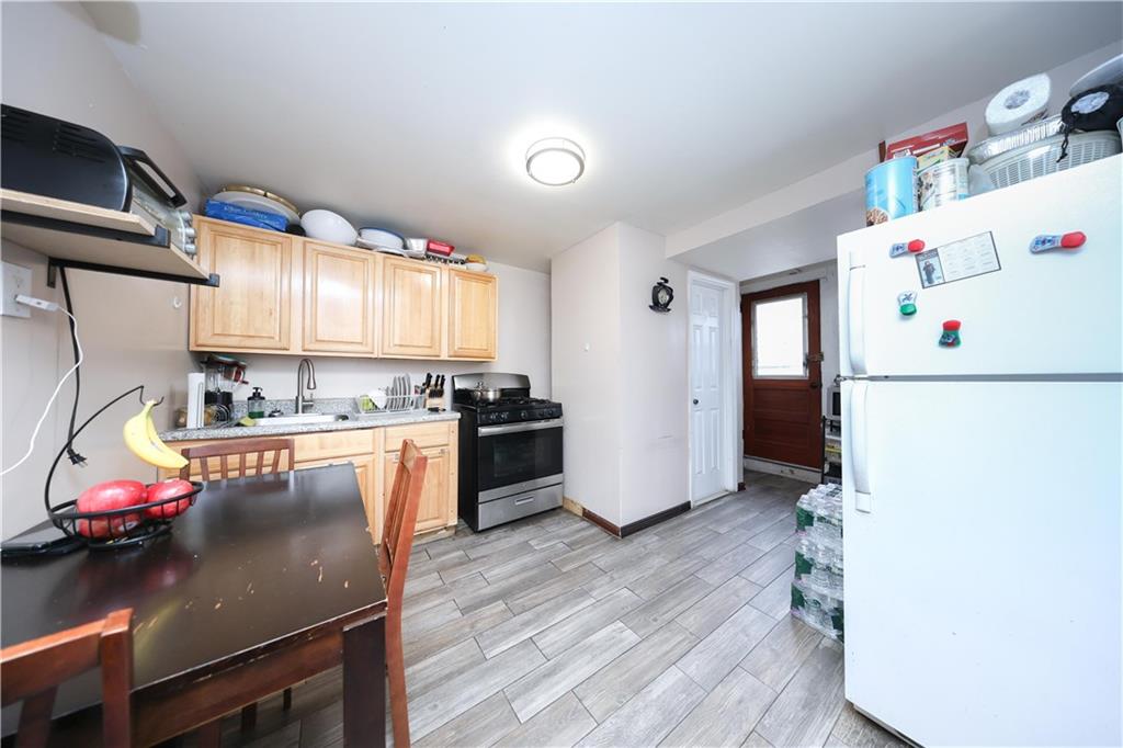 1200 East 49th Street Brooklyn, NY 11234 - Photo 27 of 30 a kitchen with a refrigerator a stove and a wooden floor