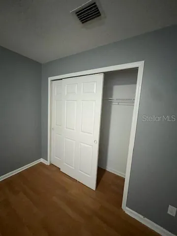 an empty room with wooden floor and closet