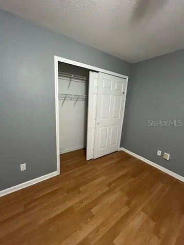 an empty room with wooden floor and closet