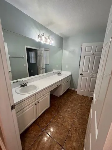 a bathroom with double vanity sink and mirror