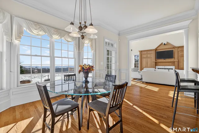 a view of a dining room with furniture a chandelier and wooden floor
