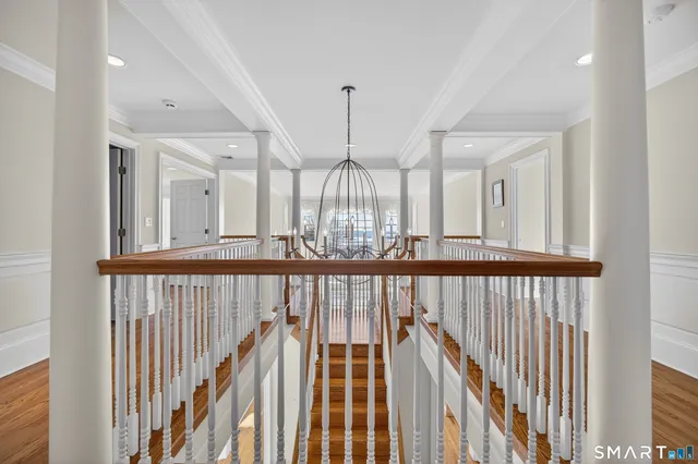 a view of a hallway with wooden floor and windows