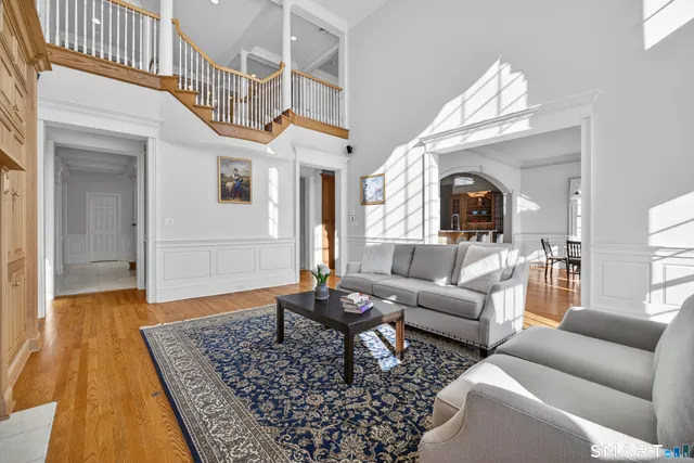 a living room with furniture a fireplace and a chandelier