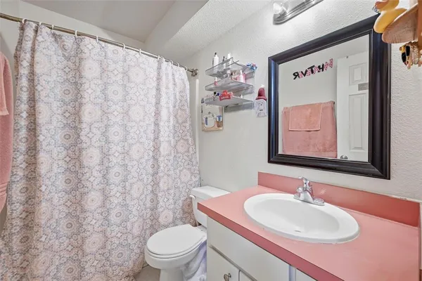a bathroom with a sink mirror vanity and toilet