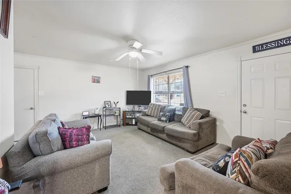 a living room with furniture ceiling fan and a rug