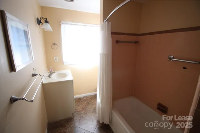 a bathroom with a tub sink and mirror