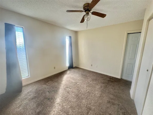 a view of a livingroom with a ceiling fan and window
