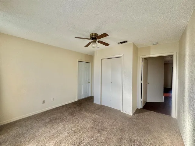 a view of an empty room and a ceiling fan