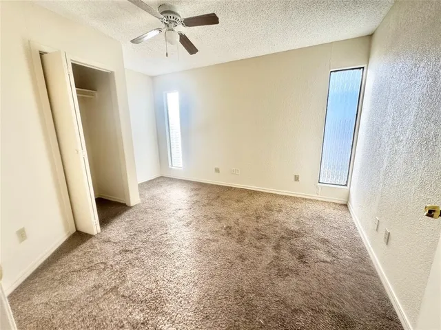 an empty room with closet and windows