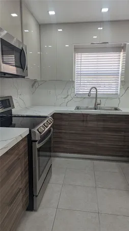 a kitchen with stainless steel appliances granite countertop a sink and a stove