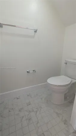 wooden floor in an empty room with a bathroom