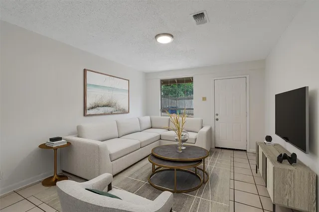 a living room with furniture a flat screen tv and a window