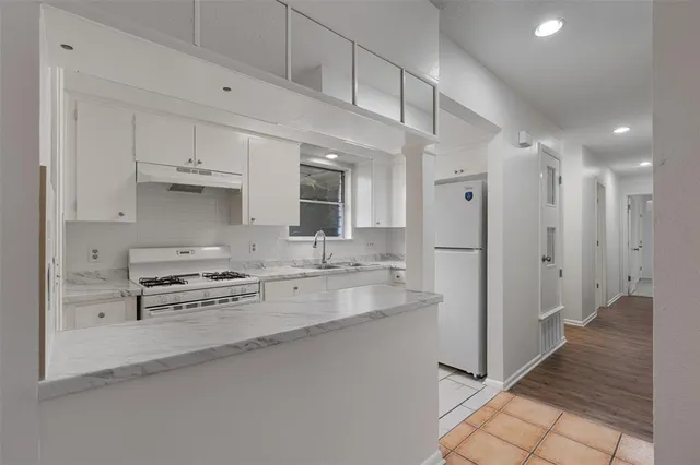 a kitchen with stainless steel appliances granite countertop a refrigerator and a sink