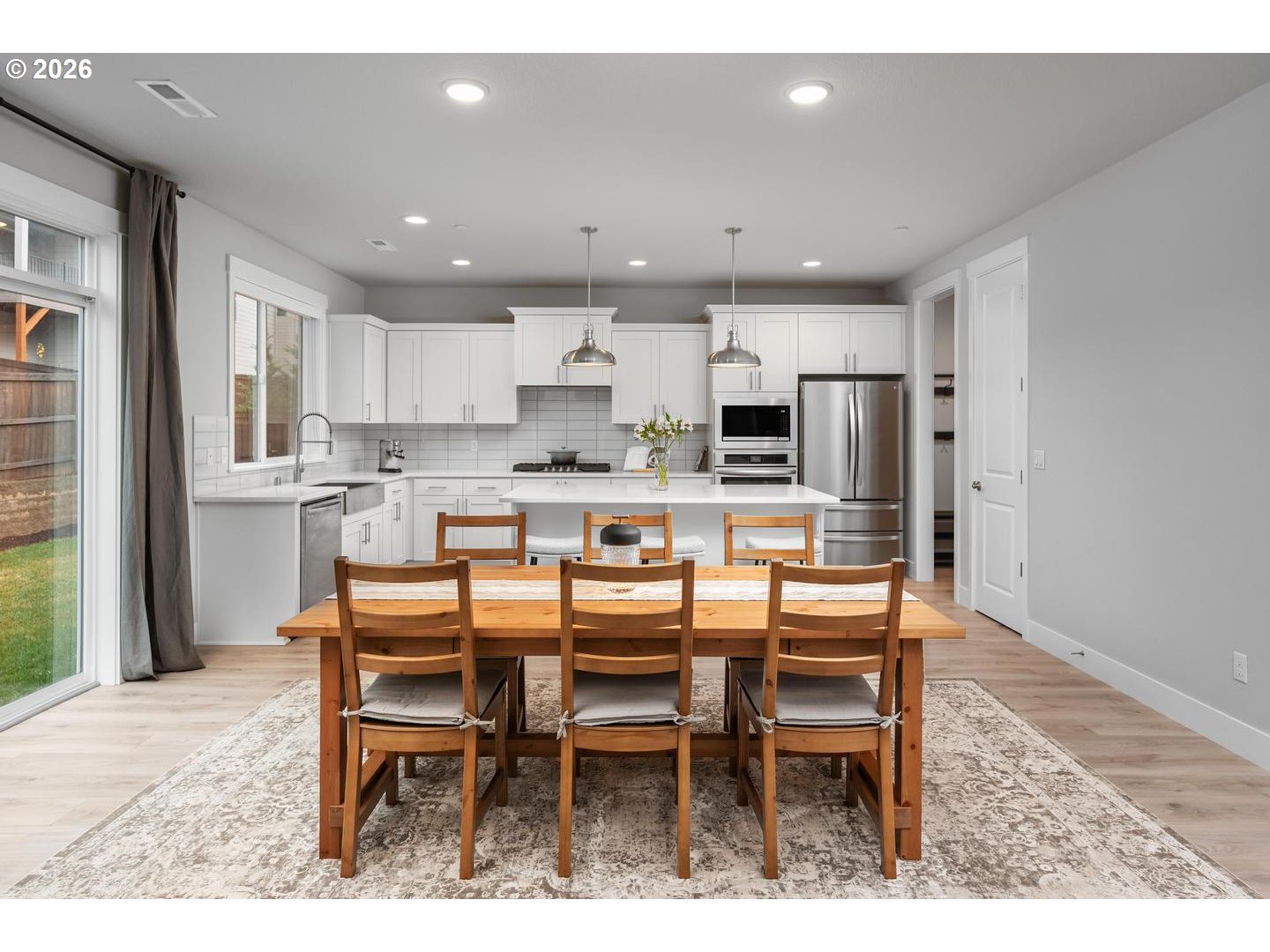 5489 North 91st Avenue Camas, WA 98607 - Photo 11 of 44 a kitchen with stainless steel appliances kitchen island granite countertop a dining table chairs sink and cabinets
