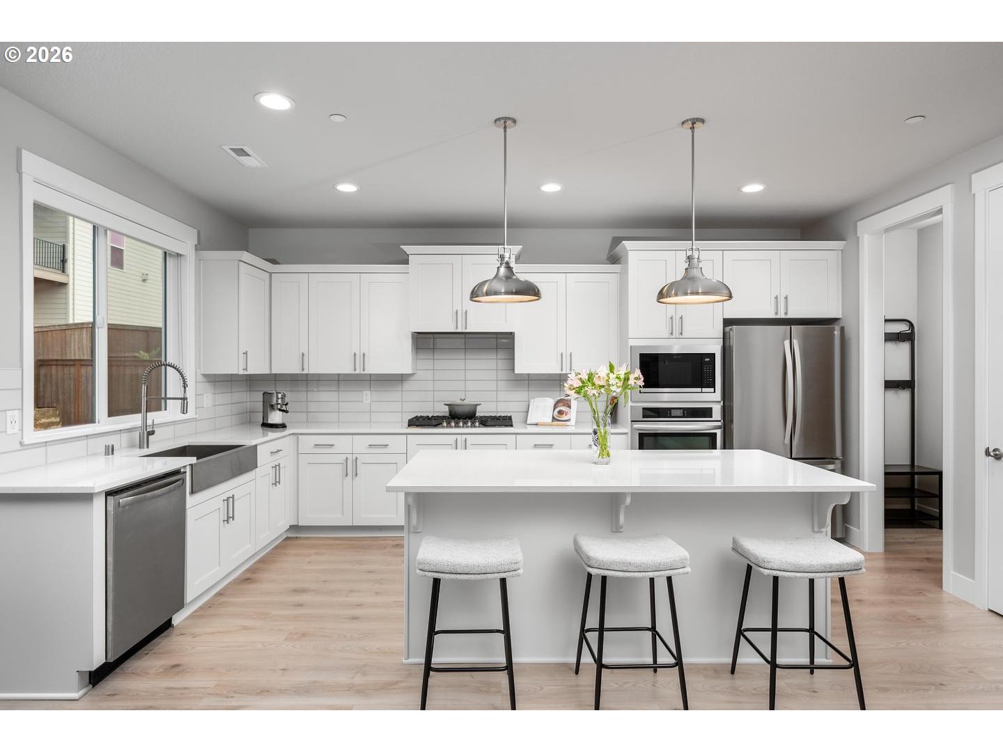 5489 North 91st Avenue Camas, WA 98607 - Photo 12 of 44 a kitchen with kitchen island stainless steel appliances a dining table chairs sink and stove top oven