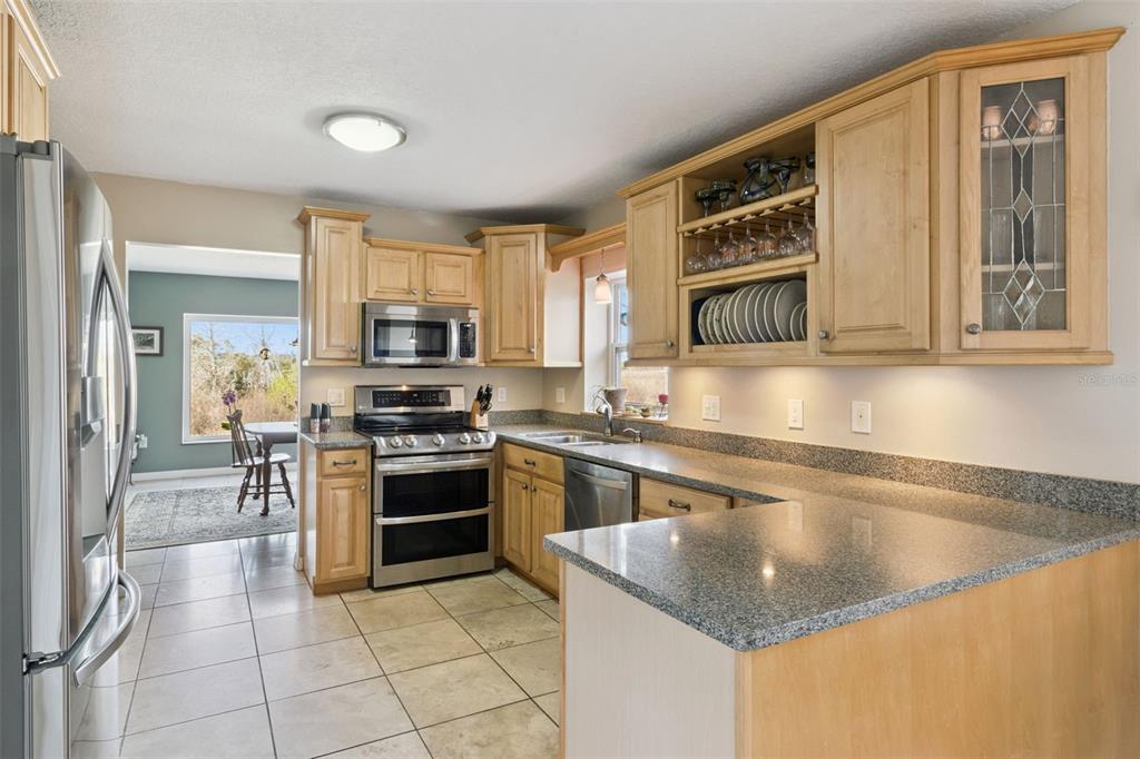 1256 Center Street Dundee, FL 33838 - Photo 13 of 41 a kitchen with stainless steel appliances granite countertop a stove top oven a sink a counter space and cabinets