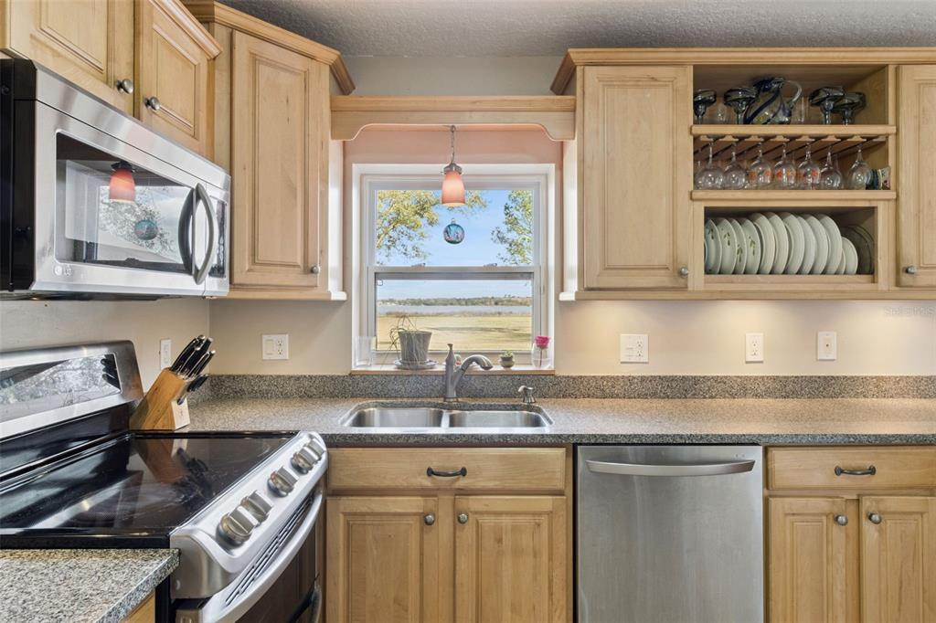 1256 Center Street Dundee, FL 33838 - Photo 8 of 41 a kitchen with stainless steel appliances granite countertop a sink and a stove next to a window