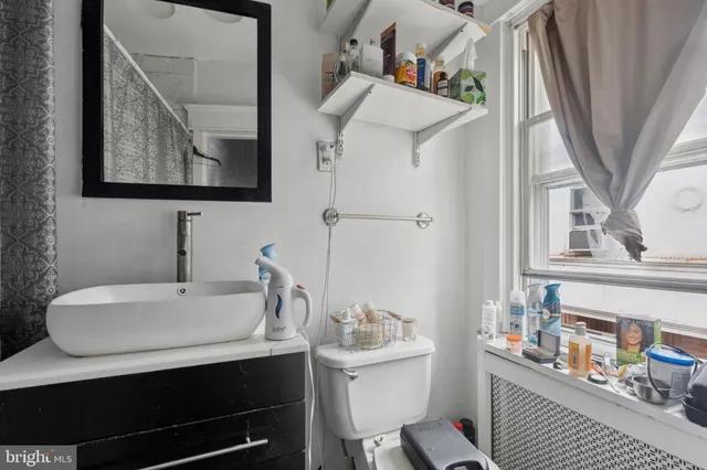 a bathroom with a sink a toilet and mirror
