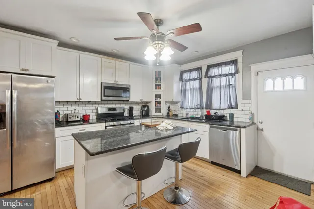 a kitchen with stainless steel appliances granite countertop a stove refrigerator sink and microwave
