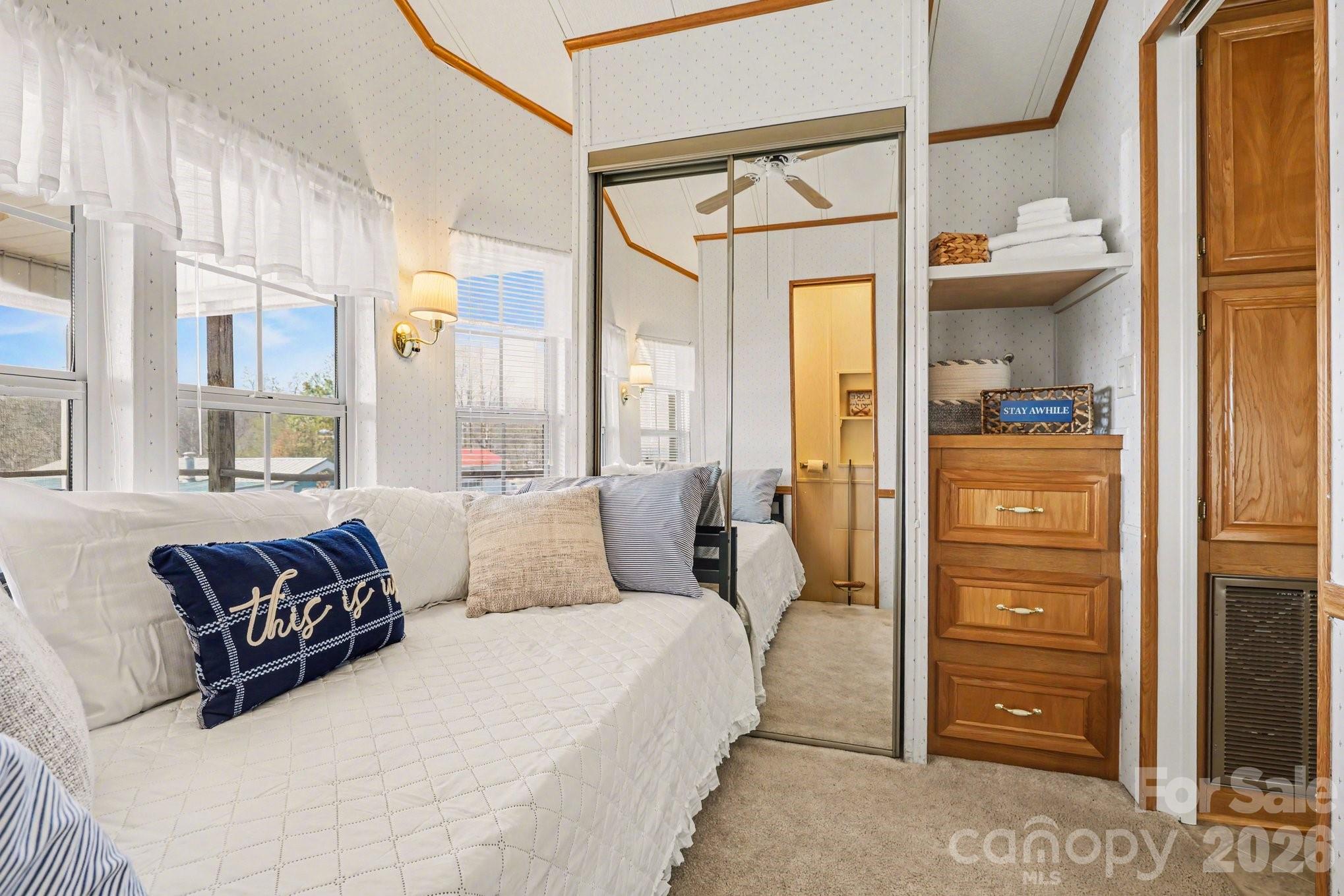 122 Maple Street New London, NC 28127 - Photo 14 of 29 a spacious bedroom with a bed and a mirror